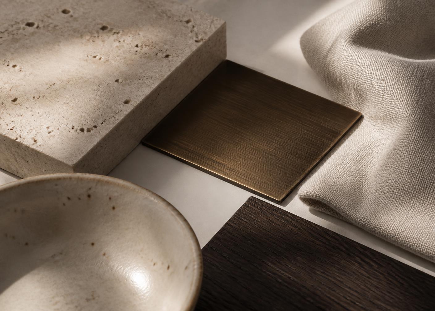 Material palette of travertine, bronze, linen and dark oak